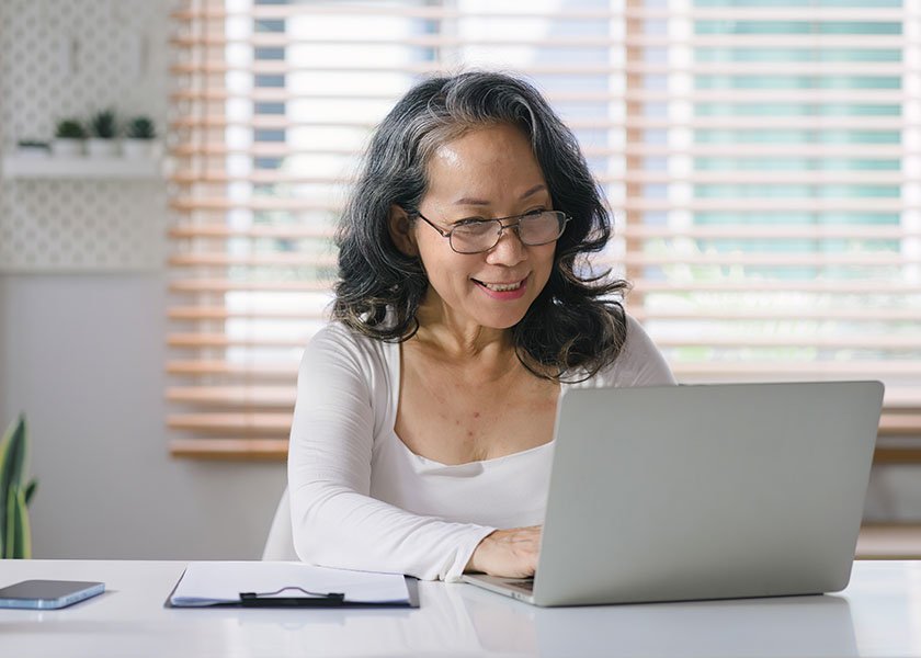 Retiree working on a laptop to learn more about Social Security spousal benefits